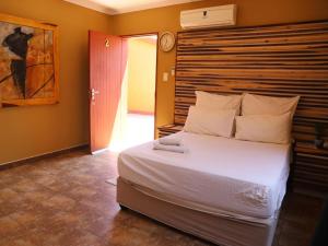 a bedroom with a large bed with a wooden headboard at Oluzizi Guesthouse in Windhoek