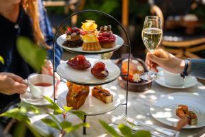 a table with three plates of desserts and a glass of wine at Hostellerie De Levernois in Levernois
