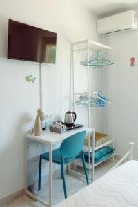 a room with a white table and a blue chair at Chianalea Guesthouse in Scilla