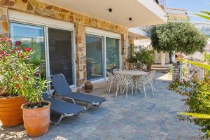 a patio with a table and chairs and plants at Dimitra Beach Apartments - Thassos Skala Potamias in Skala Potamias