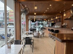 a restaurant with a bar and tables and chairs at Best Inn Hostel and Café Patong Beach in Patong Beach