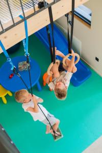 two children playing on the swings in a play gym at Blacksmith house - SPA, Heated outdoor pool, Kids zone in Varaždinske Toplice