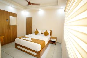 a bedroom with a bed and a window at Misty Suite Infopark in Cochin