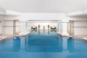 a large swimming pool with columns and blue water at Sunset Apartment - 7th Floor Double Tree in Brighton & Hove
