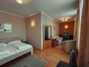 a bedroom with a bed and a living room at Hotel Roháč in Trstená