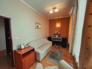 a living room with a white couch and a tv at Hotel Roháč in Trstená