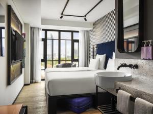 a hotel room with a bed and a sink at TRIBE Phnom Penh Post Office in Phnom Penh +148 photos