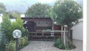 un giardino con panchina e alberi di fronte a una casa di Appartamenti Villa Rosa a Cala Gonone