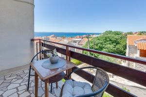 a table and chairs on a balcony with a view at Apartmani Katica in Diklo