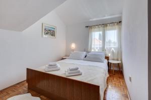 a bedroom with a large bed with towels on it at Apartmani Katica in Diklo