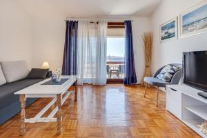 a living room with a couch and a tv at Apartmani Katica in Diklo