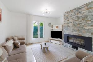 a living room with a couch and a fireplace at Maison du Périgord in Pazayac