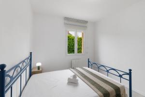 a blue bed in a white room with a window at Maison du Périgord in Pazayac +19 photos