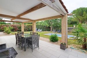 a patio with a table and chairs under a pergola at Maison du Périgord in Pazayac