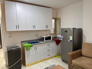 a kitchen with white cabinets and a refrigerator at Lavanda Beach Resort Studio - Panoramic Sea & Pool View in Abū Rudays