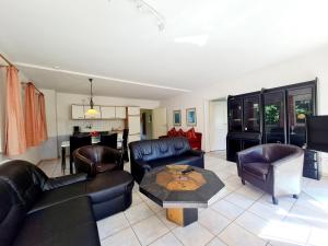 a living room with leather furniture and a table at Ferienhof Peter in Vollerwiek