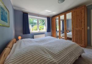 a bedroom with a large bed and a window at Ferienhof Peter in Vollerwiek