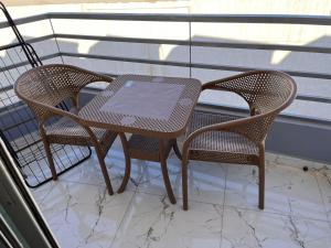 a table and two chairs on a balcony at Lavanda Beach Resort Studio - Panoramic Sea & Pool View in Abū Rudays +6 photos
