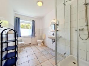 a bathroom with a shower and a toilet and a sink at Ferienhof Peter in Vollerwiek +66 photos