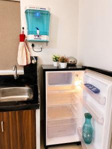 an open refrigerator with its door open in a kitchen at BNBees Anjuna Goa in Chapora +2 photos
