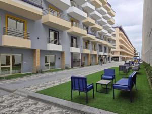 a row of chairs on a lawn in front of a building at Lavanda Beach Resort Studio - Panoramic Sea & Pool View in Abū Rudays