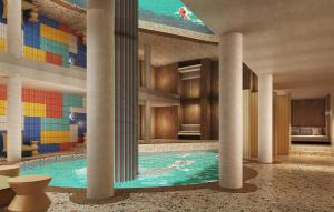 a large swimming pool in a building with columns at Hotel Enzian - Adults Only in Obertauern