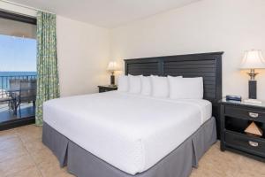a bedroom with a large bed and a balcony at Phoenix X 504 in Orange Beach +56 photos