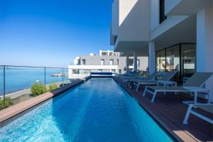 a swimming pool with chairs and the ocean in the background at Dedaj Resort - Villa Tina in Zadar +50 photos