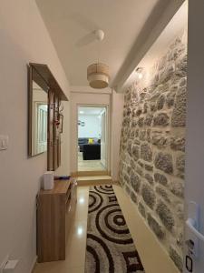 a hallway with a stone wall and a mirror at Apartman Teodora in Risan +6 photos