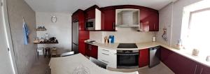 a kitchen with red cabinets and a counter top at Meraki in Finisterre