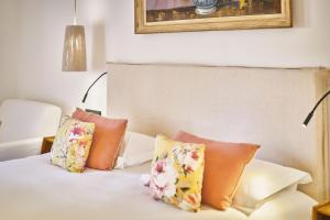 a bed with four pillows on it in a room at La Ferme D'Augustin in Saint-Tropez +279 photos
