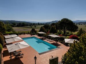 an outdoor swimming pool with umbrellas and chairs at B&B Villa Cardeto in Anghiari