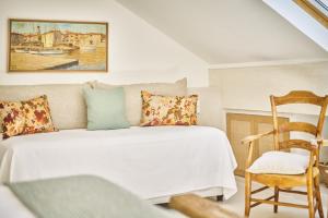 a bedroom with a bed and a chair at La Ferme D'Augustin in Saint-Tropez