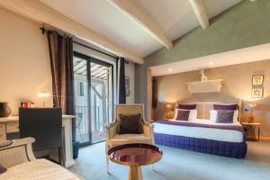 a hotel room with a bed and a chair at Le Mas de Guilles in Lourmarin +57 photos
