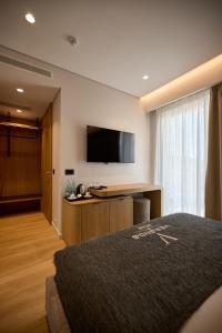 a hotel room with a bed and a flat screen tv at Veranda Hotel by Mirage in Ksamil