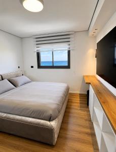 a bedroom with a bed and a flat screen tv at דירת החלומות באשדוד in Ashdod +15 photos