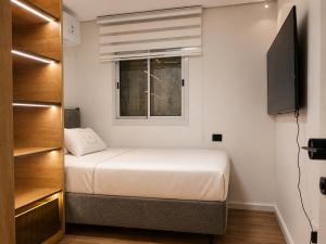 a small bedroom with a bed and a window at דירת החלומות באשדוד in Ashdod