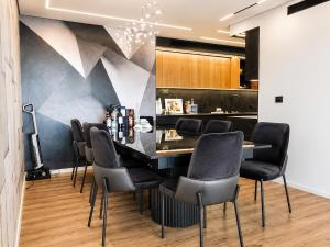 a bar with black chairs and a painting on the wall at דירת החלומות באשדוד in Ashdod