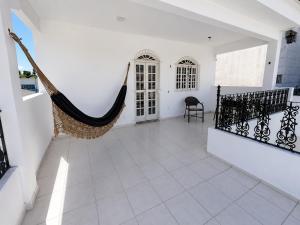 a house with a hammock in the middle of a room at Encantos do Mar Hostel in Recife