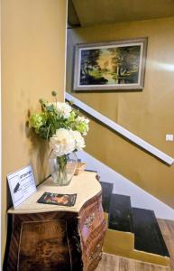 a table with a vase of flowers on top of a staircase at Hôtel des Jacobines in Chalon-sur-Saône