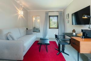 a living room with a couch and a desk at Le Mas de Guilles in Lourmarin