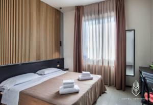 a bedroom with a large bed with two towels on it at Verdemilia Hotel in Anzola dell'Emilia