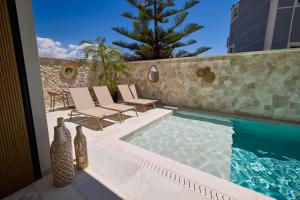 a swimming pool with lounge chairs and a table at Veranda Hotel by Mirage in Ksamil
