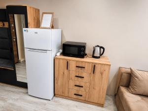 a white refrigerator next to a table with a microwave at Apartment Underground, Premium Apartment in Ruse City Centre in Ruse