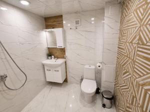 a white bathroom with a toilet and a sink at Apartment Underground, Premium Apartment in Ruse City Centre in Ruse