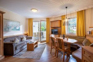 a living room with a couch and a table at Alpenresidenz-Sonnwend - Wellness Apartments nahe Zillertal Arena in Zell am Ziller