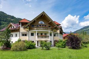 a large house with a balcony in a field at Alpenresidenz-Sonnwend - Wellness Apartments nahe Zillertal Arena in Zell am Ziller