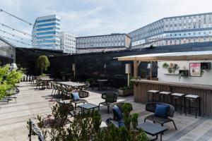 a patio with tables and chairs and buildings at Clarion Hotel Arlanda Airport Terminal in Arlanda