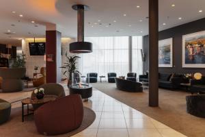 a lobby with couches and chairs in a building at Clarion Hotel Arlanda Airport Terminal in Arlanda