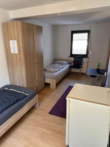 a bedroom with two beds and a cabinet and a table at Landhaus Butzbach in Butzbach